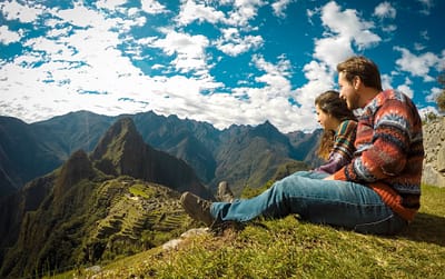 Couple looking from a high mountain to Machu Picchu